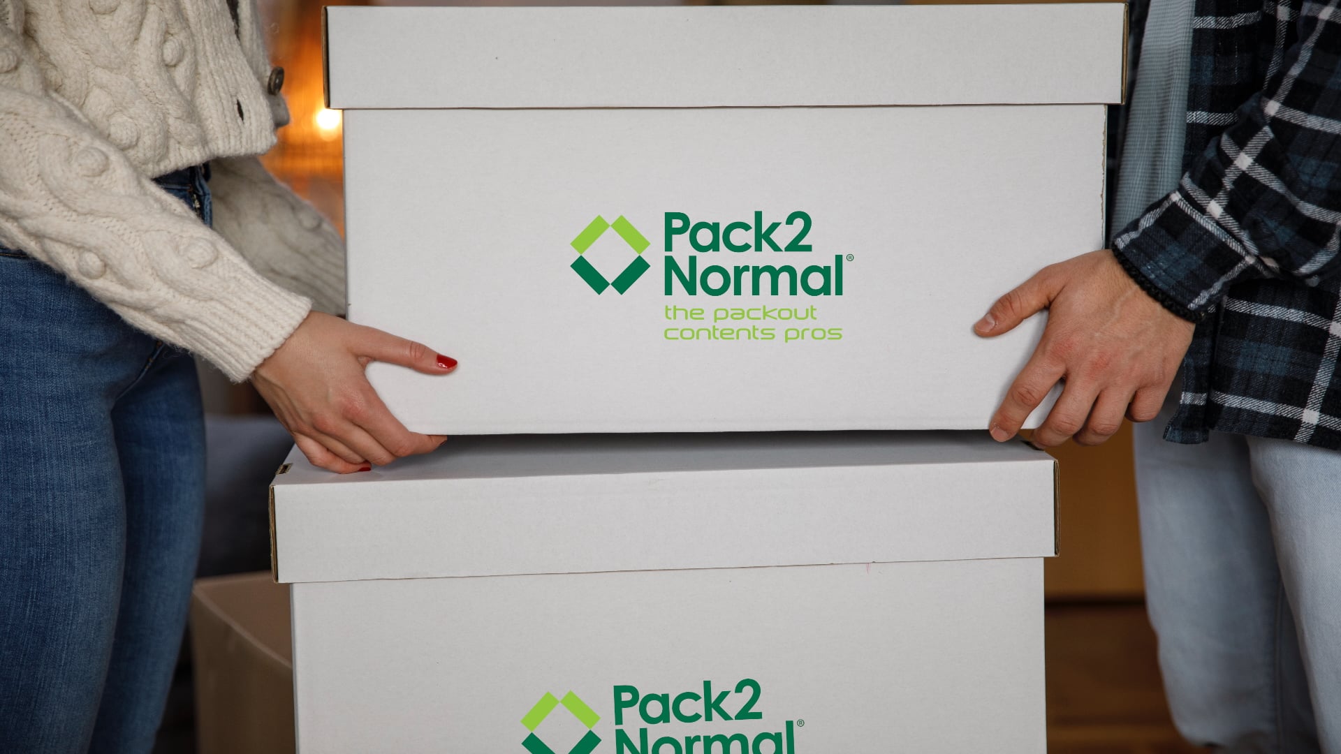 People holding stacked moving boxes