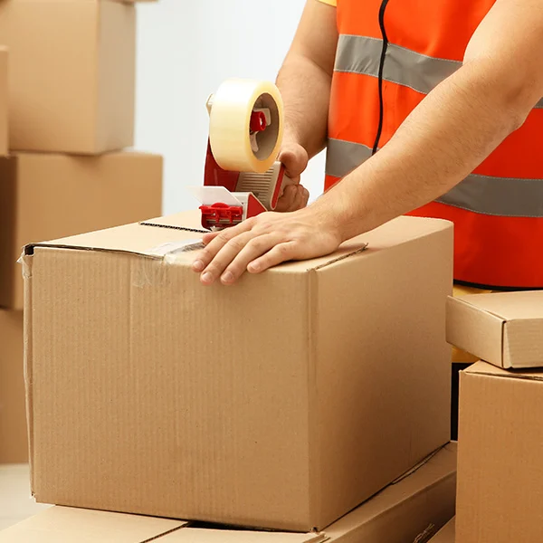 Worker sealing cardboard box with tape