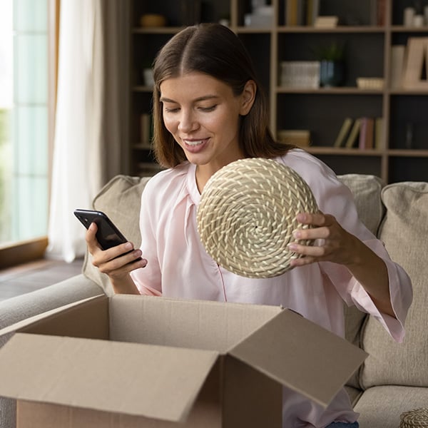 Woman unboxing and smiling at phone